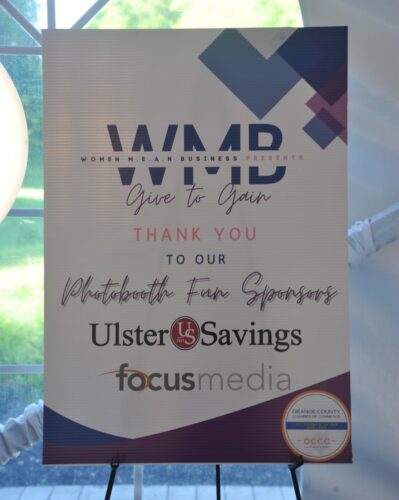 Event banner for Women in Business with 'Give to Gain' and 'Thank you to our Photobooth Fan Sponsors' including Ulster Savings and Focus Media logos.