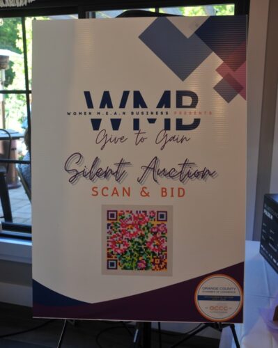 Poster for a Silent Auction event titled 'Give to Gain' with QR code to scan & bid, featuring floral image and OC Chamber of Commerce logo.