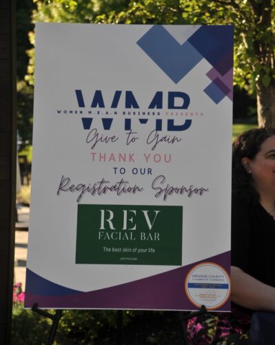 Event sponsor poster for a women's business event, showing 'Give to Gain' and the REV Facial Bar logo with a chamber seal on the bottom right.